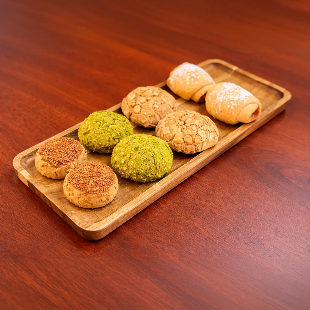 Assorted Turkish cookie platter on a wooden board featuring pistachio, almond, sesame and apple-filled wrap cookies at Cafe Galata Guelph