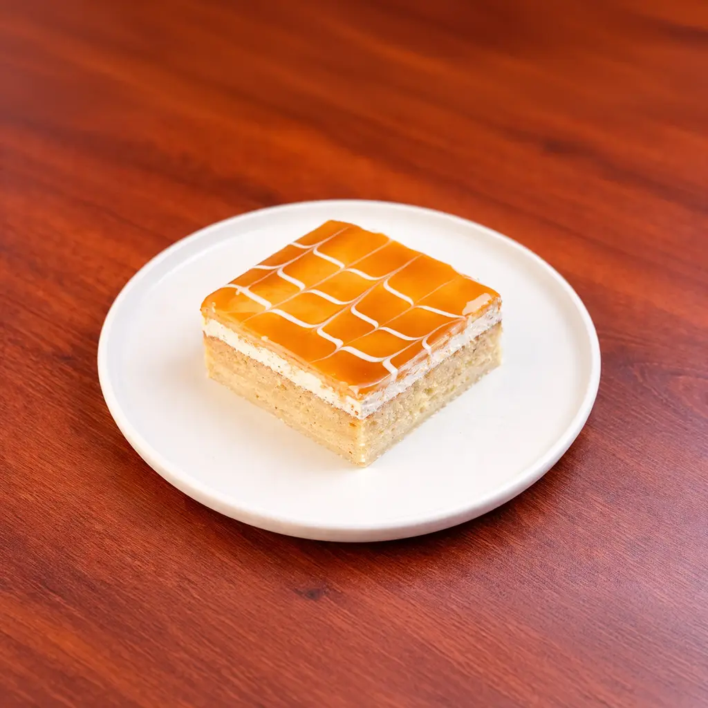 Caramel tres leches cake square soaked in three milks topped with a smooth amber caramel glaze and white cream lattice at Cafe Galata Guelph