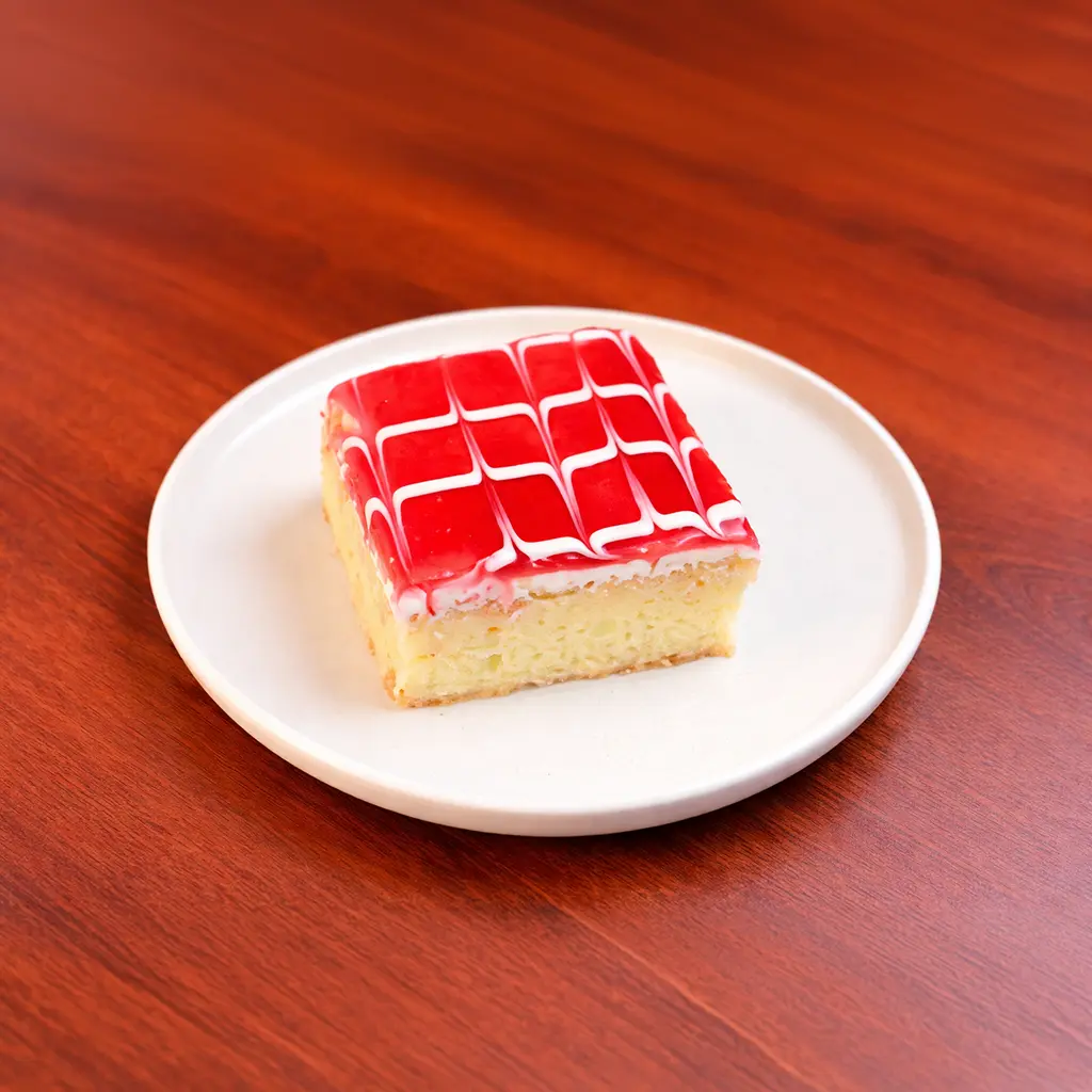 Raspberry tres leches cake square soaked in three milks topped with vivid red raspberry glaze and white cream lattice at Cafe Galata Guelph