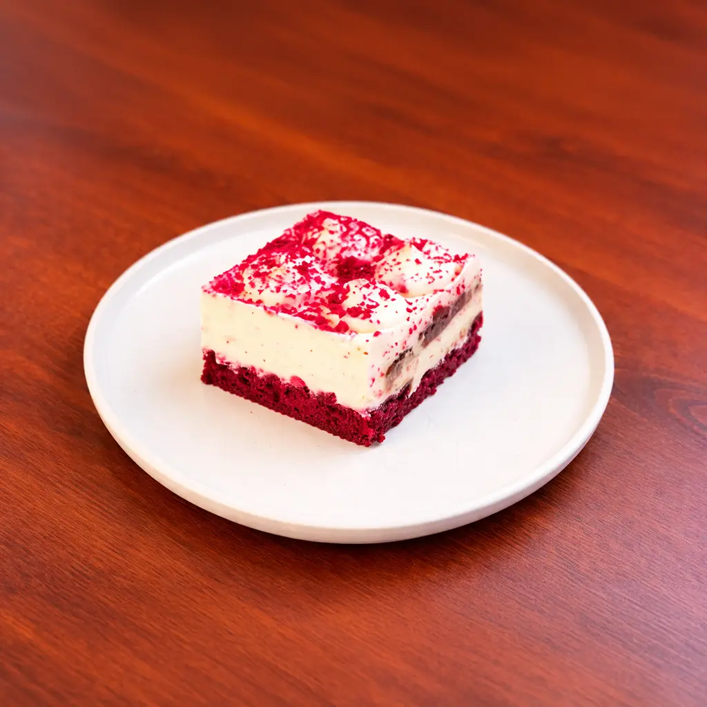 Red velvet cake square with moist red sponge base, cream cheese filling and red velvet crumb topping at Cafe Galata Guelph