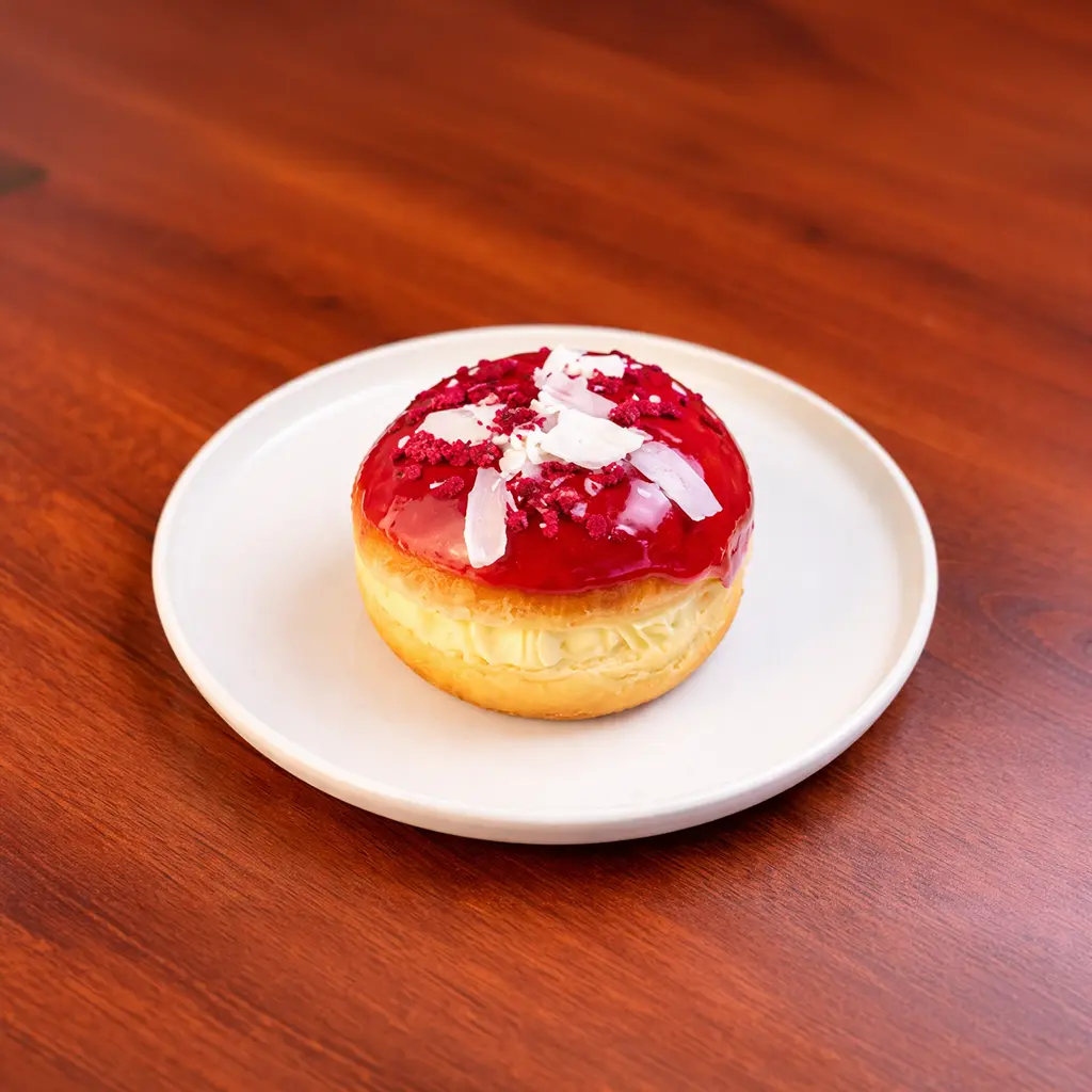 Sour cherry filled donut topped with bright red cherry glaze and white chocolate shards at Cafe Galata Guelph