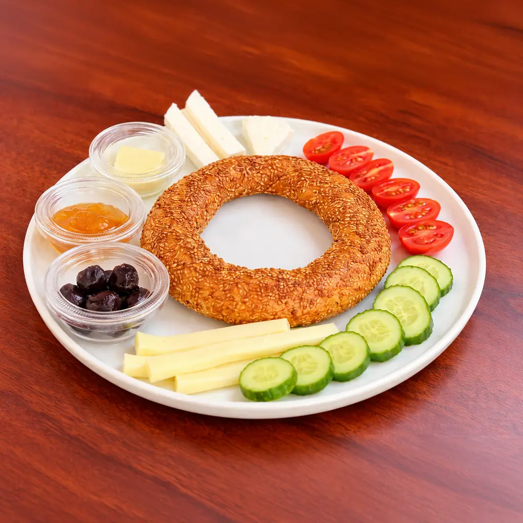 Traditional Turkish breakfast plate with sesame simit, white cheese, string cheese, cherry tomatoes, cucumber slices, black olives, butter and jam at Cafe Galata Guelph